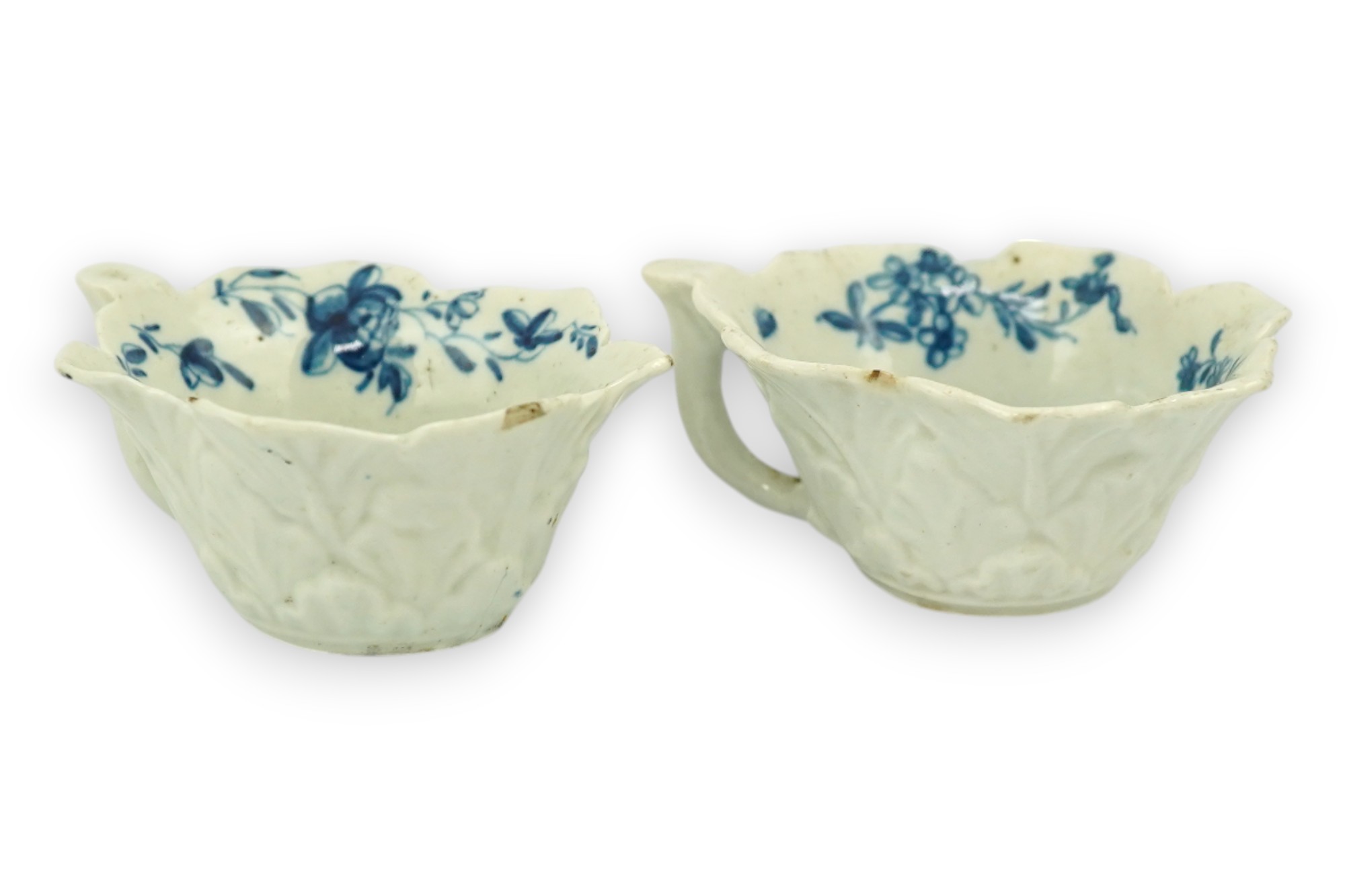 A pair of Worcester blue and white butterboats, c.1758-60, with differing blue and white decoration, 8cm wide. Condition - fair, some chips commensurate with age, one cracked.